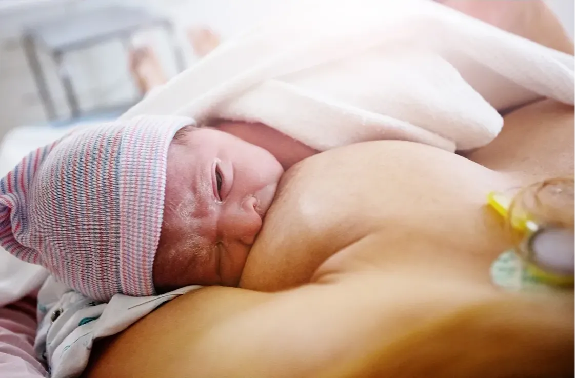 Women Breastfeeding Baby On Bed