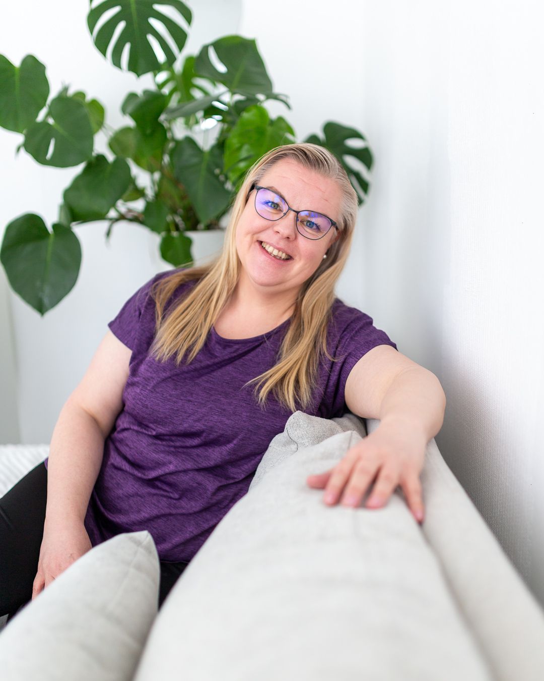 muutosvalmentaja iloisena sohvalla
