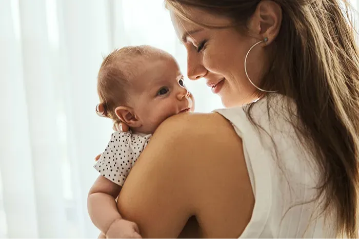 Woman holding her baby and smiling