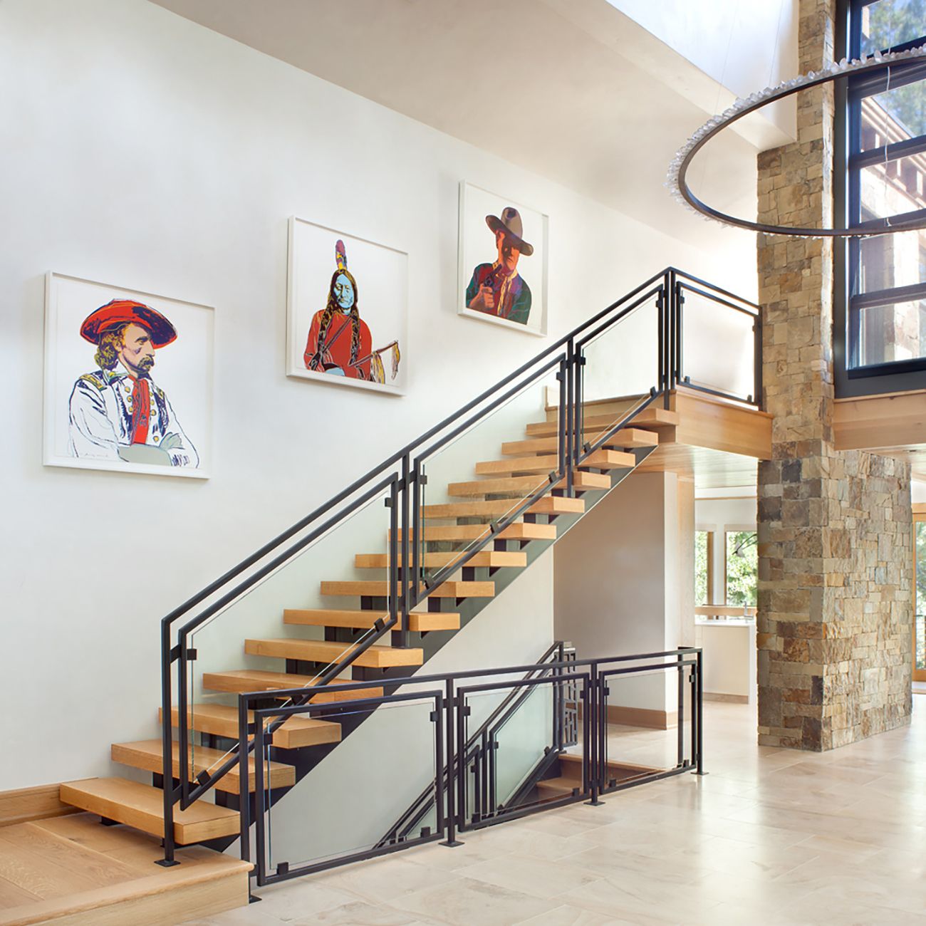 Warhol Cowboys and Indians series on a staircase wall in a modern home