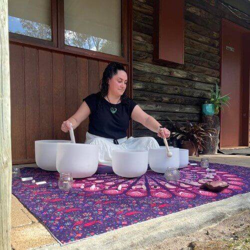 Student practicing crystal singing bowls during Holistic Wellness Academy sound healing training