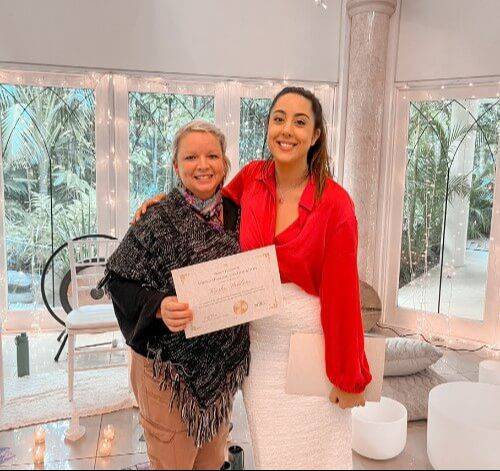 Kirsty Bramwell presenting a Sound Healing Chakra Practitioner certification to a graduate