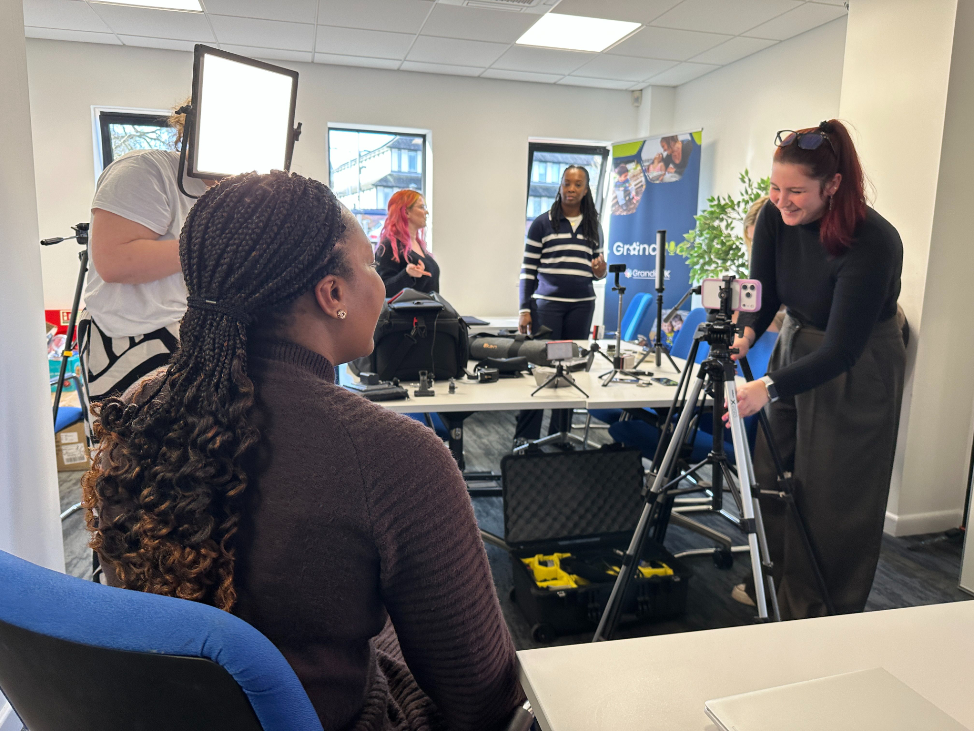A group of three individuals learning how to film professional video on their smartphones during a Business Film School workshop in Hertfordshire.