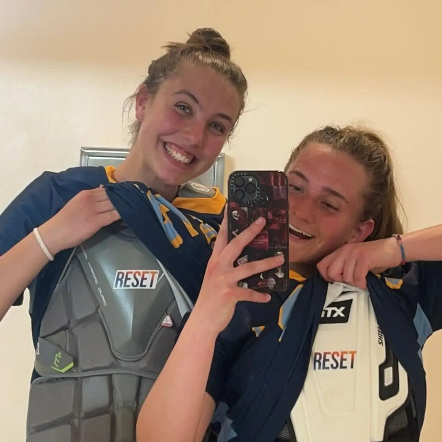 Two lacrosse players with RESET stickers