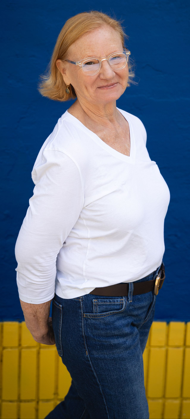 photo of Ce, a woman with light skin and chin-length blond hair, smiling upward