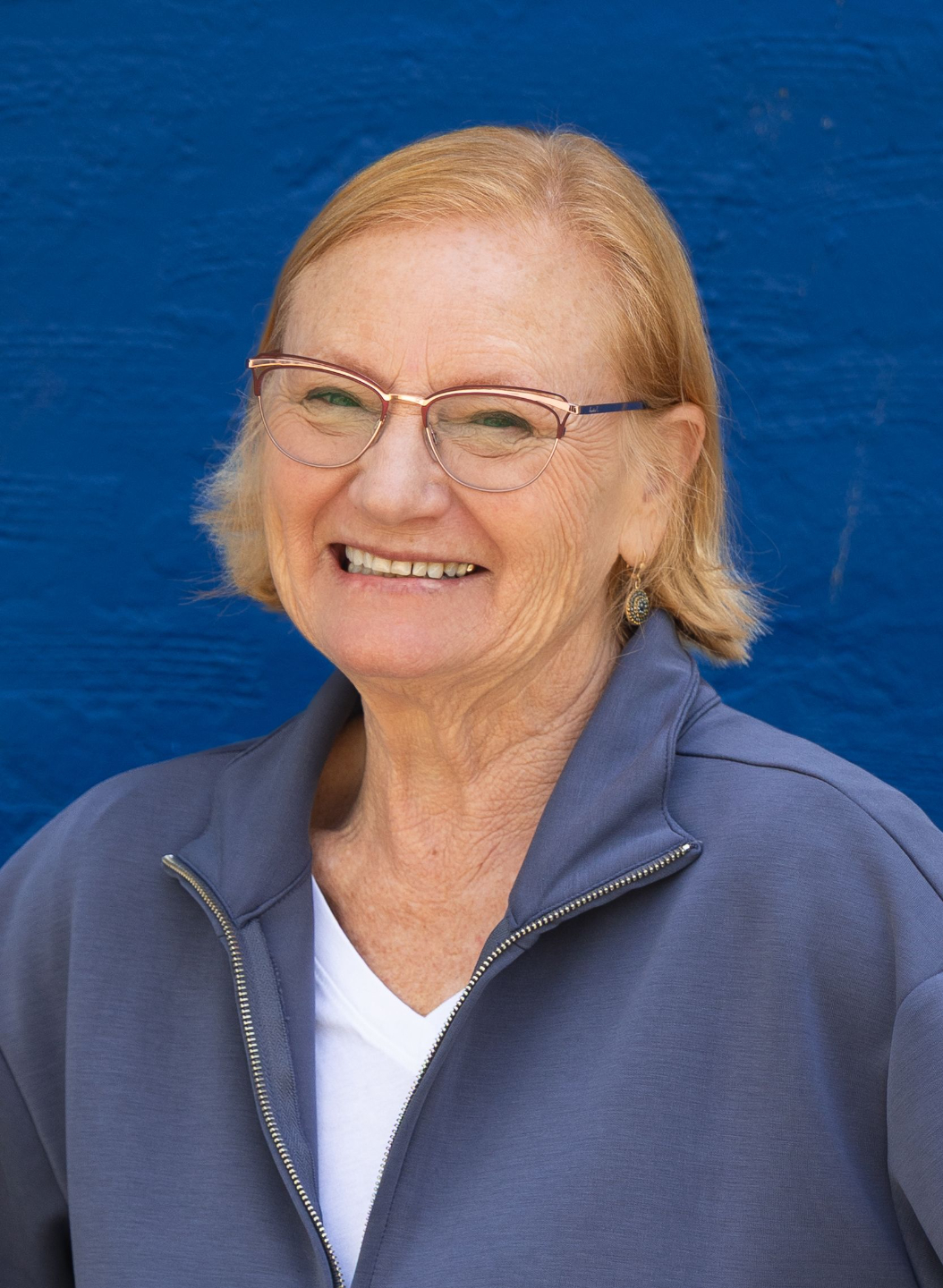 photo of Ce, a woman with light skin and chin-length blond hair, smiling at the camera