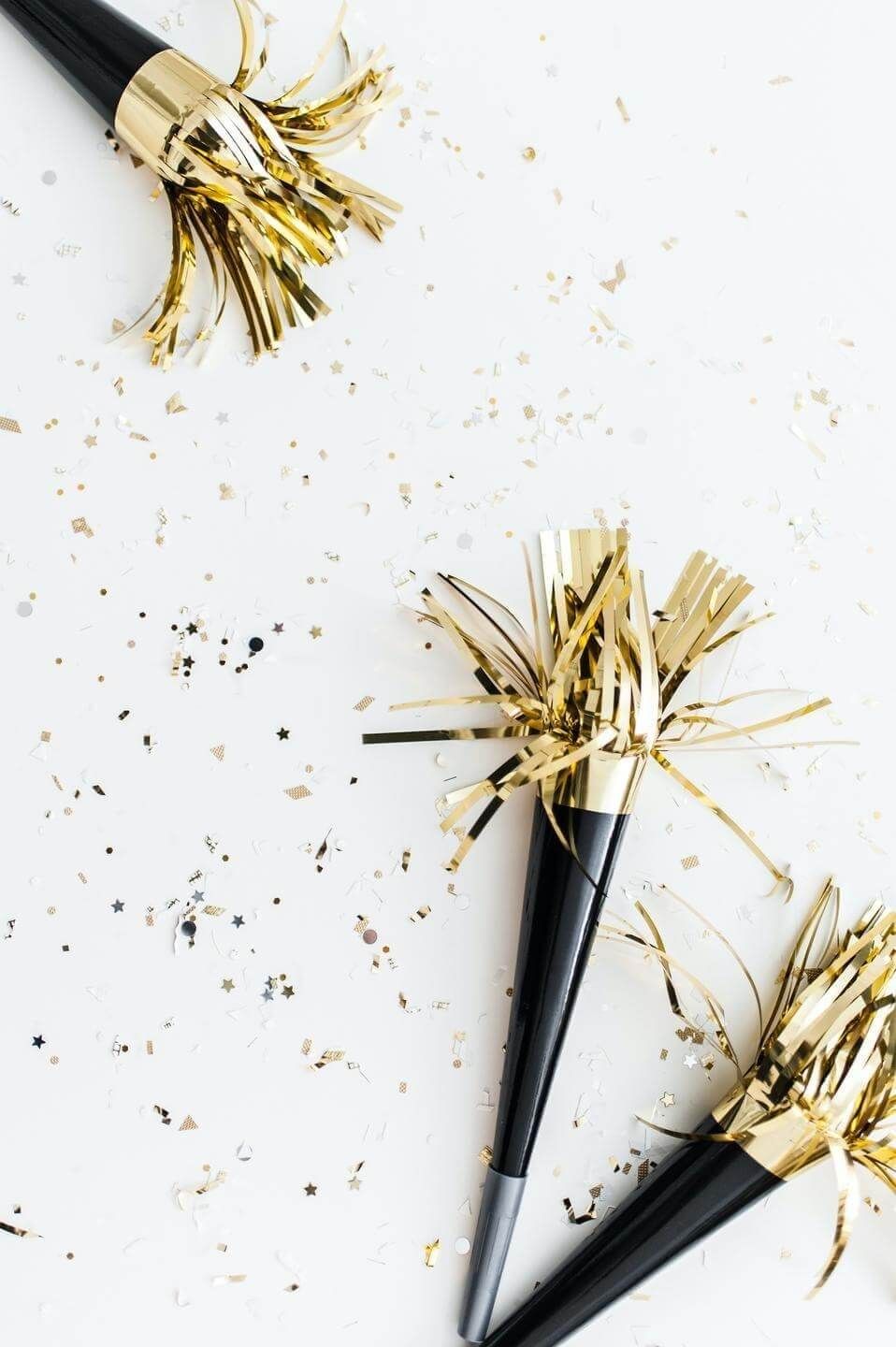 White background with black and gold confetti and streamers. 