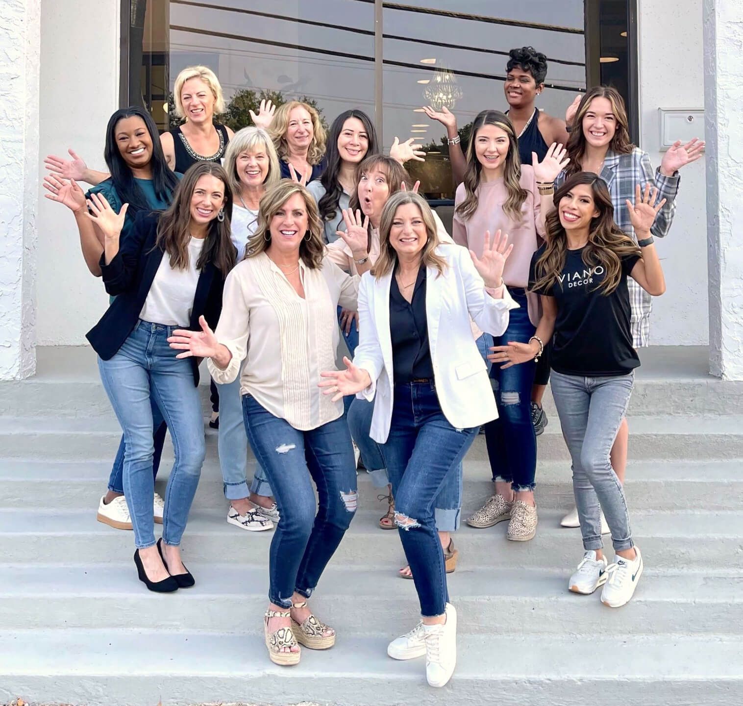 group of master class students in front of studio with hands up and smiling 