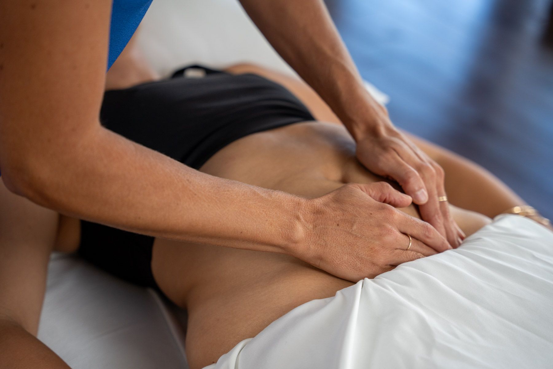 Physical therapist in blue leggings and white sports bra doing a lunge