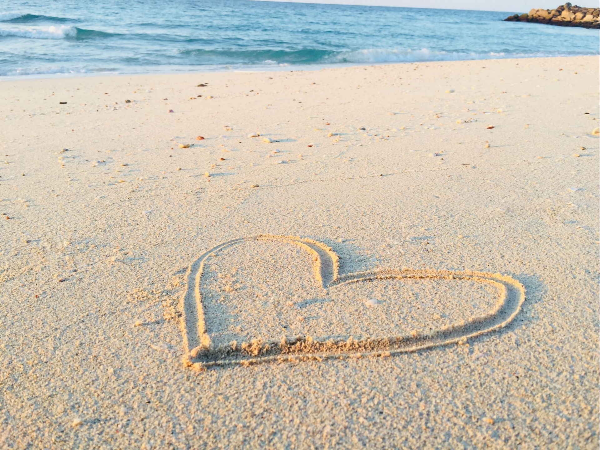 heart drawn in the sand on a beach