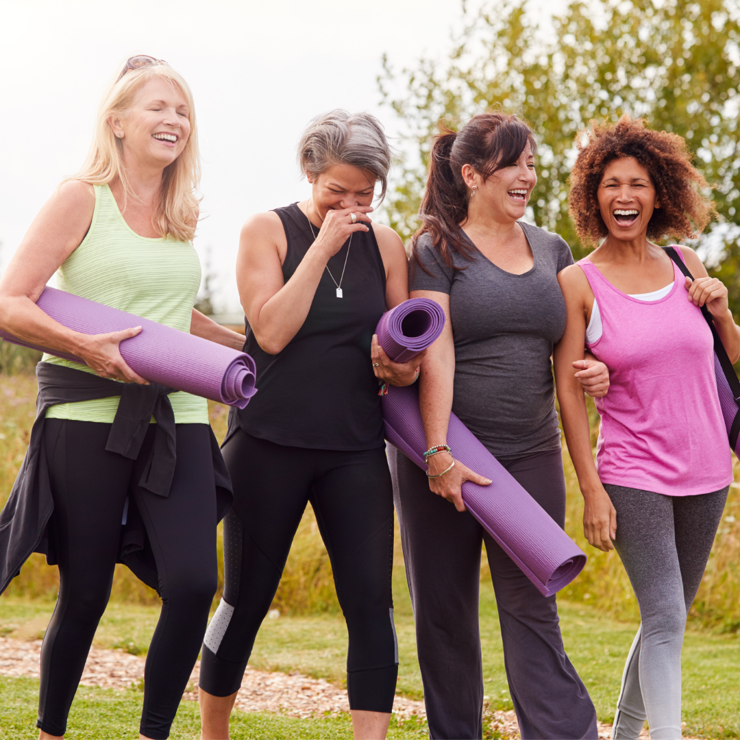 Practice calendar on tablet device alongside phone and laptop showing Julie Ann Garrido teaching yoga for menopause