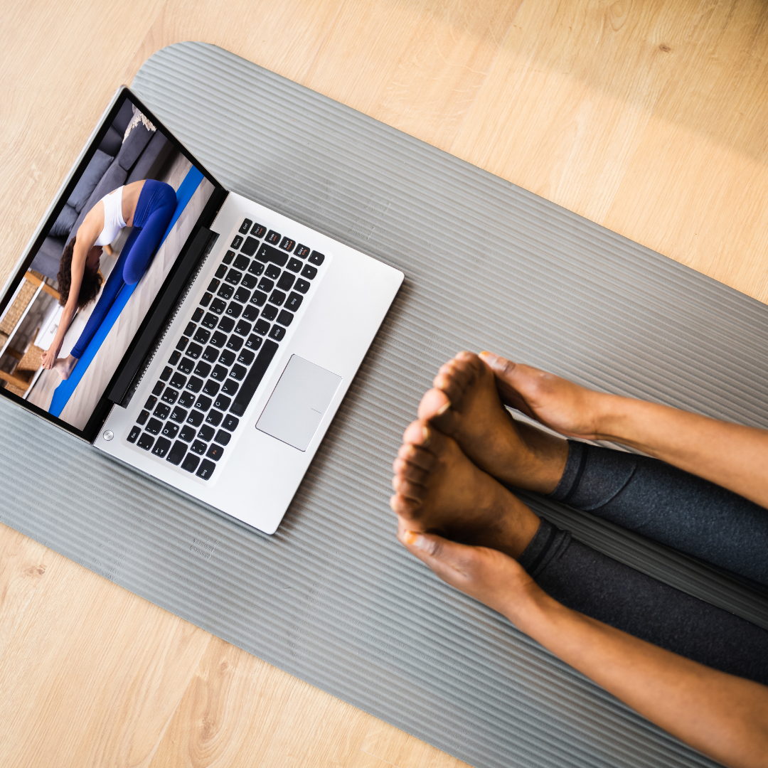 Practice calendar on tablet device alongside phone and laptop showing Julie Ann Garrido teaching yoga for menopause