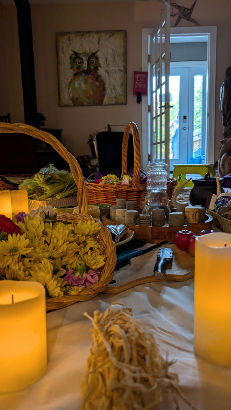 Ninth Wave Art's community space set up for a cycle gathering with candles and basket of flowers