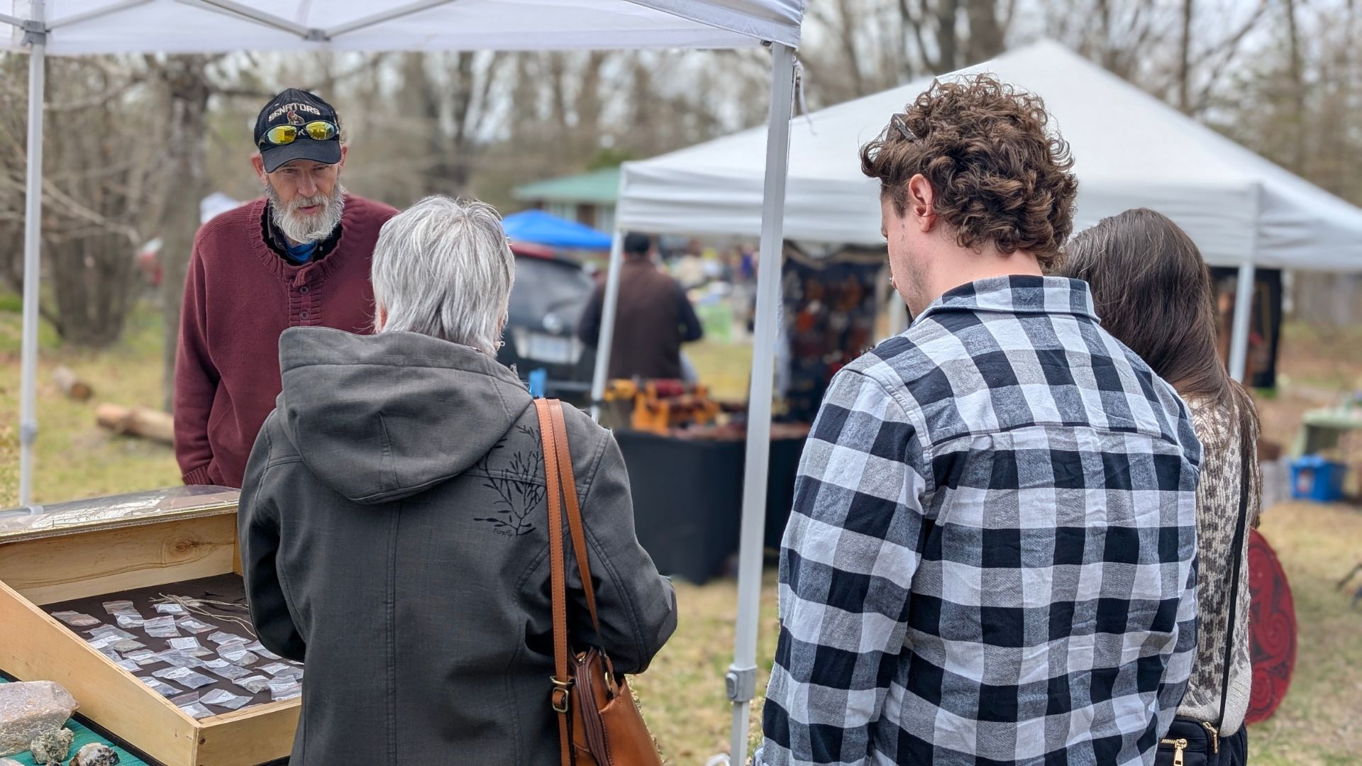 vendor in conversation with shoppers at an artisan market