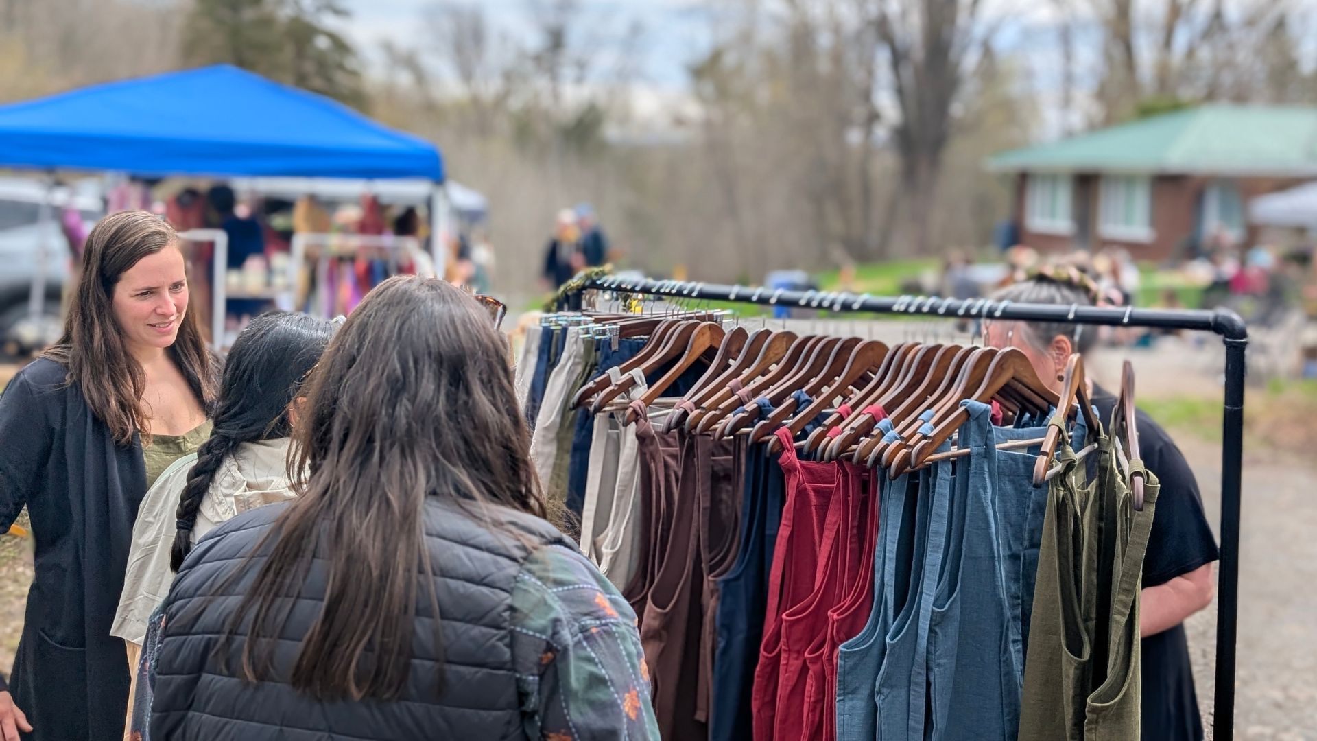 people browsing rack with linnen clothing at a spring market