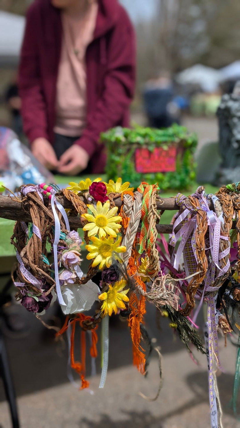 Person browsing rack with linnen cloths at an outdoor market
