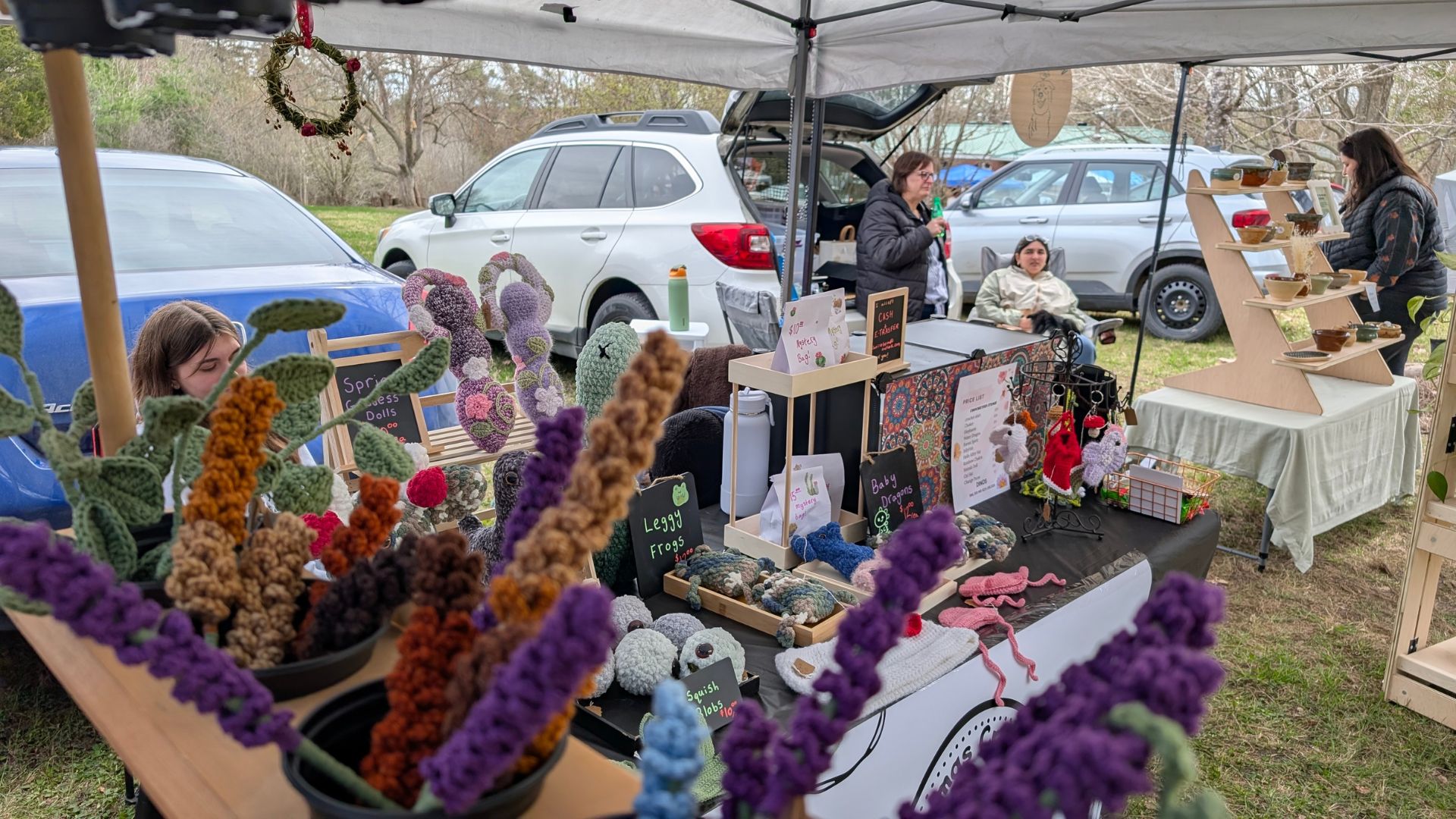 vendor stalls with knitted crafts and pottery set on a field