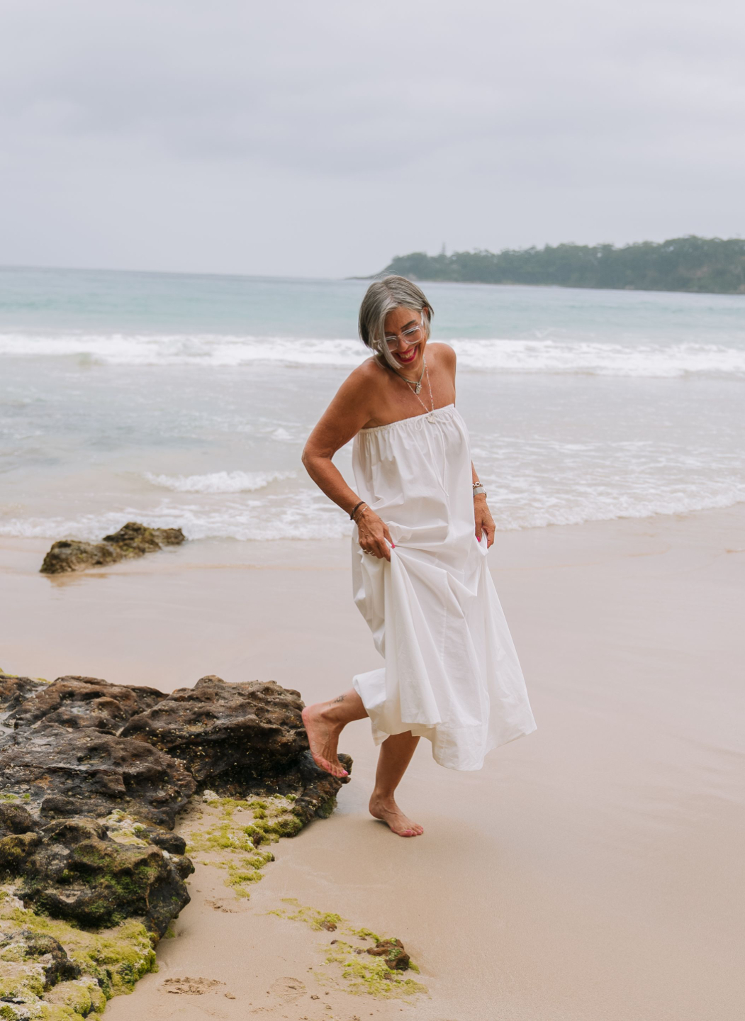 Catherine wearing white strapless dress at the beach ready to live her most fabulous life