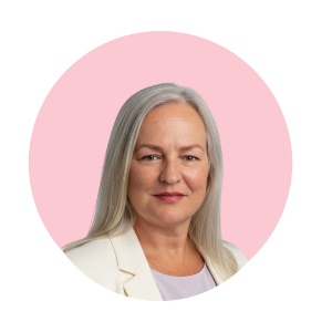 portrait of Tania Gorry, business coach, silver shoulder length hair, NDIS Provider, founder, with pink round background