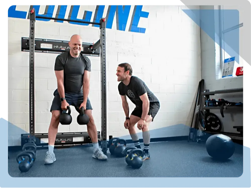 Two men training with kettlebells at Athletes' Potential physical therapy clinic in Columbus, OH