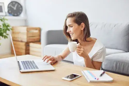 coaching client smiling while on her laptop