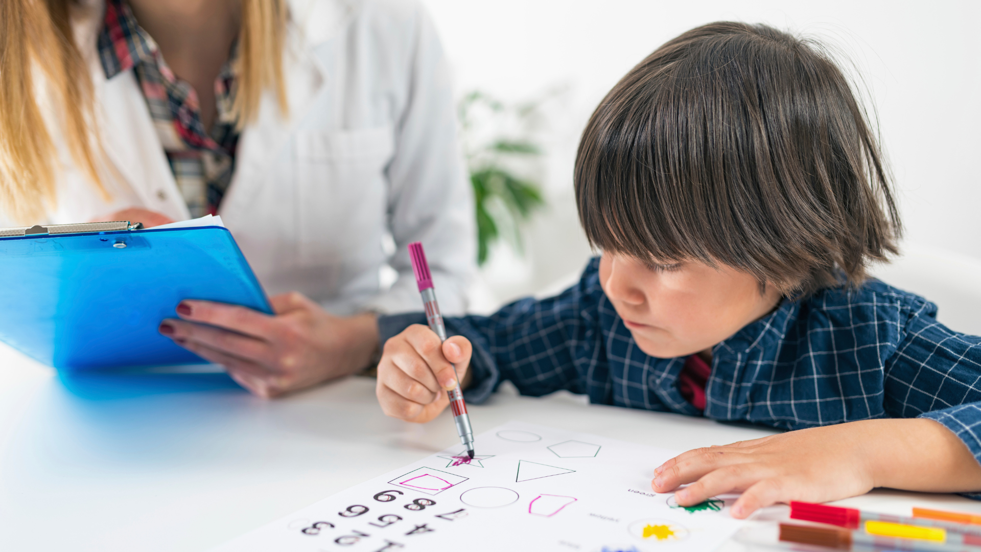 Boy completing shapes and numbers during a psychology session, representing cognitive assessments, learning needs and school support.
