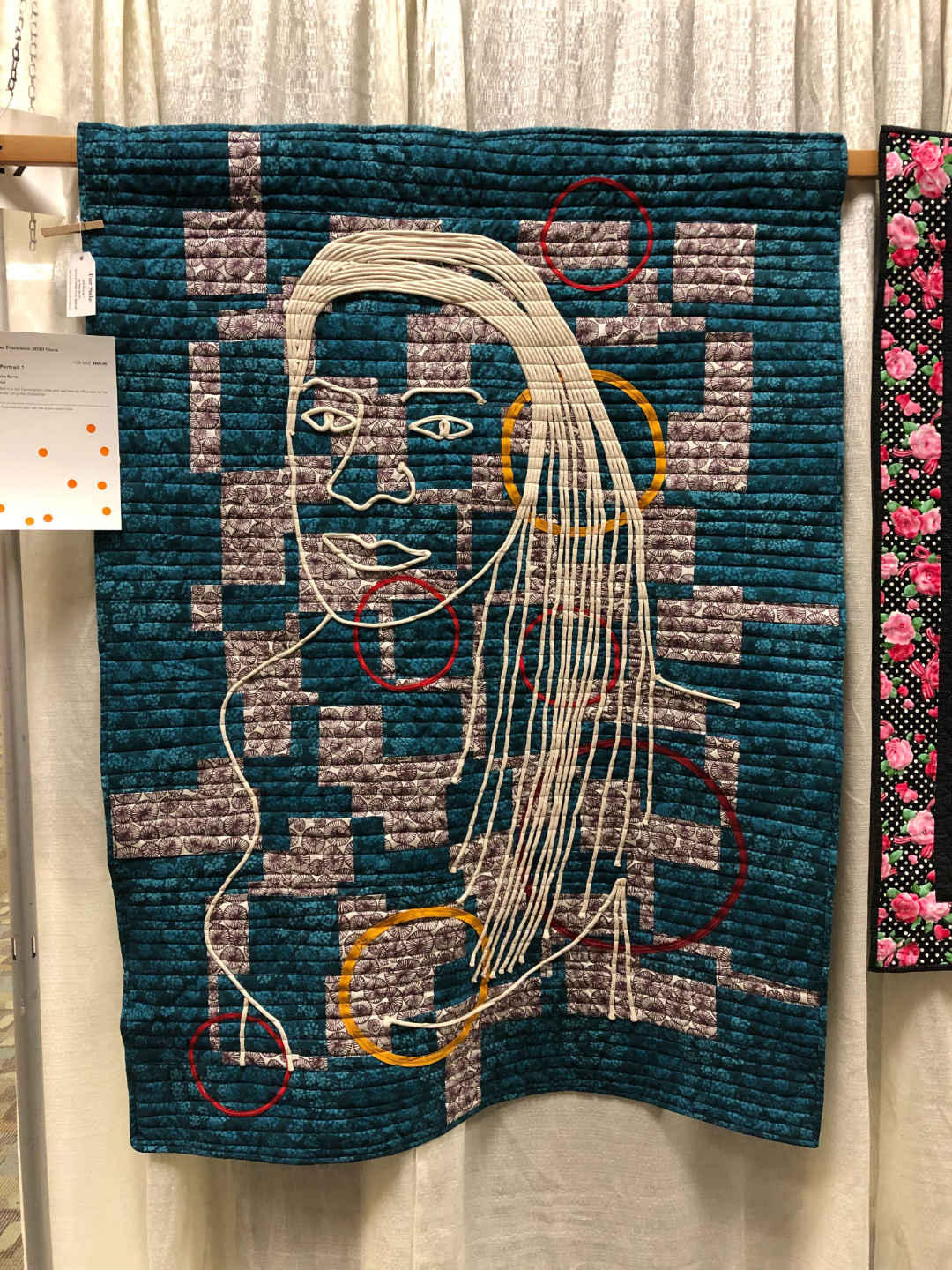 Turquoise and purple geometric background with a face drawn using white rope