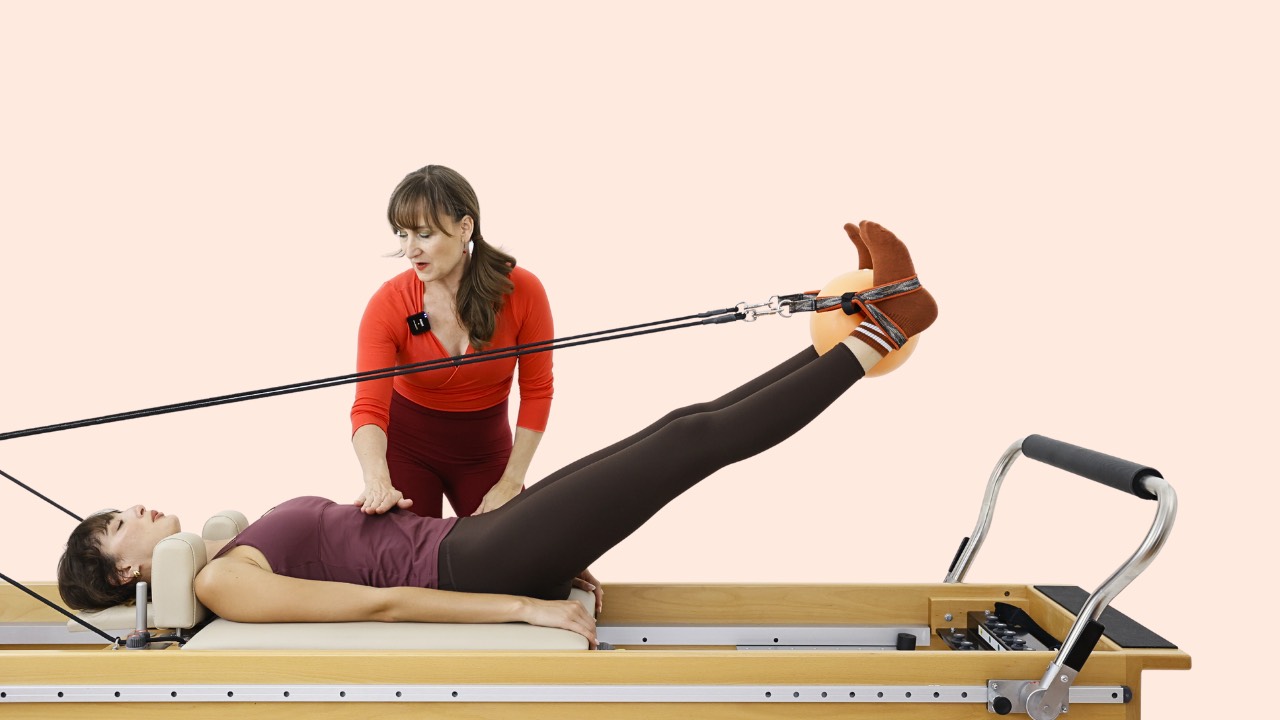 Louise teaching feet in straps on the Pilates Reformer