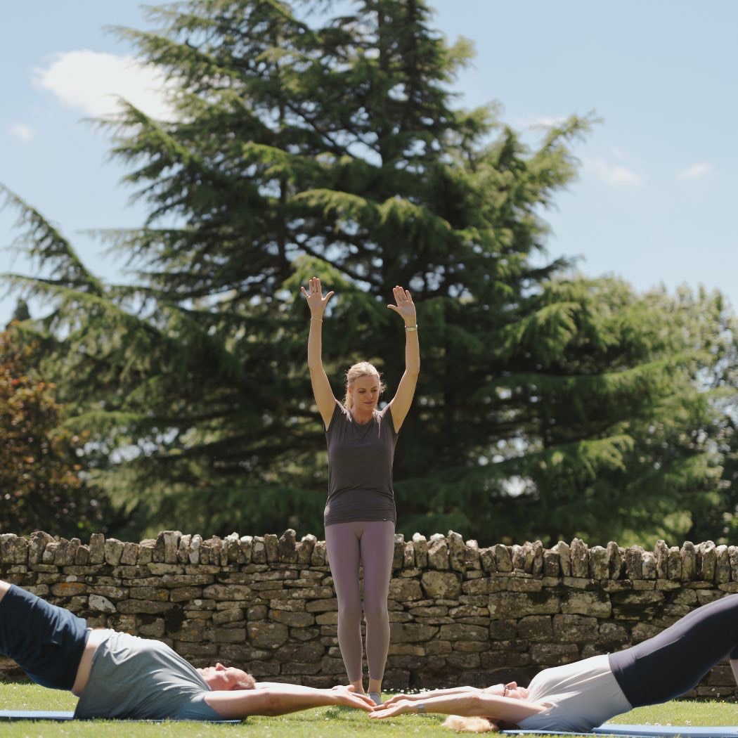 Kari Sherman instructing two clients during a live Pilates class, providing personalised coaching and technique guidance.