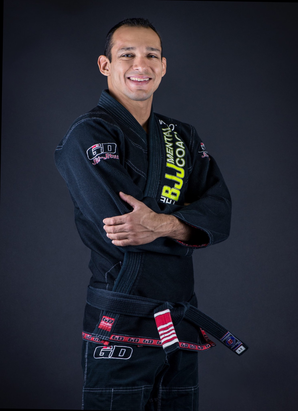 Portrait of Gustavo Dantas, 6th degree Brazilian Jiu-Jitsu black belt and BJJ Mental Coach, wearing a black gi