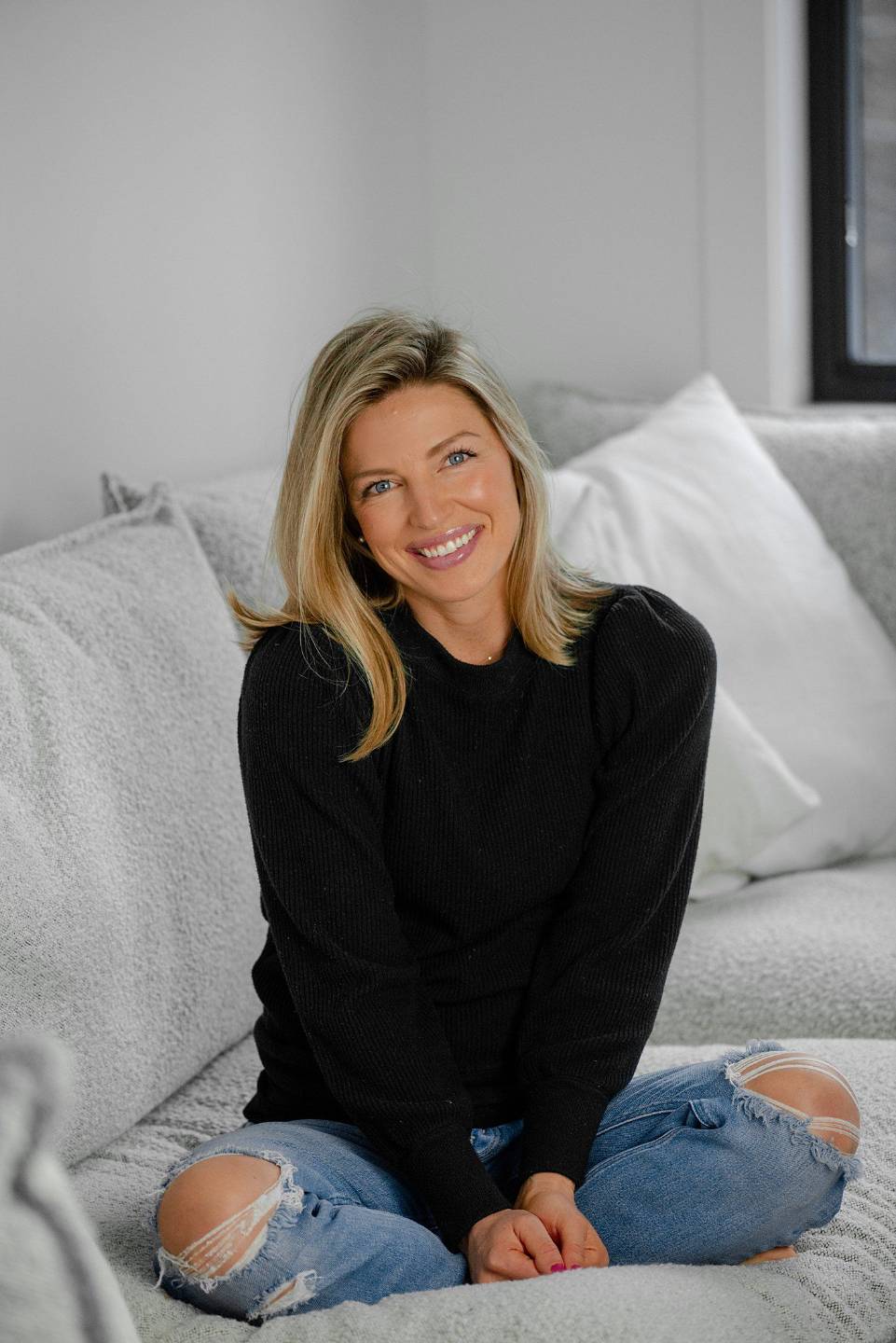 Kate smiling while sitting on a sofa