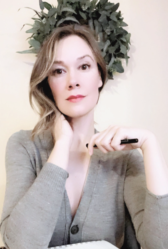 Somatic writing coach [Your Name] sitting with a notebook, offering a warm and grounded invitation to join the writing cohort