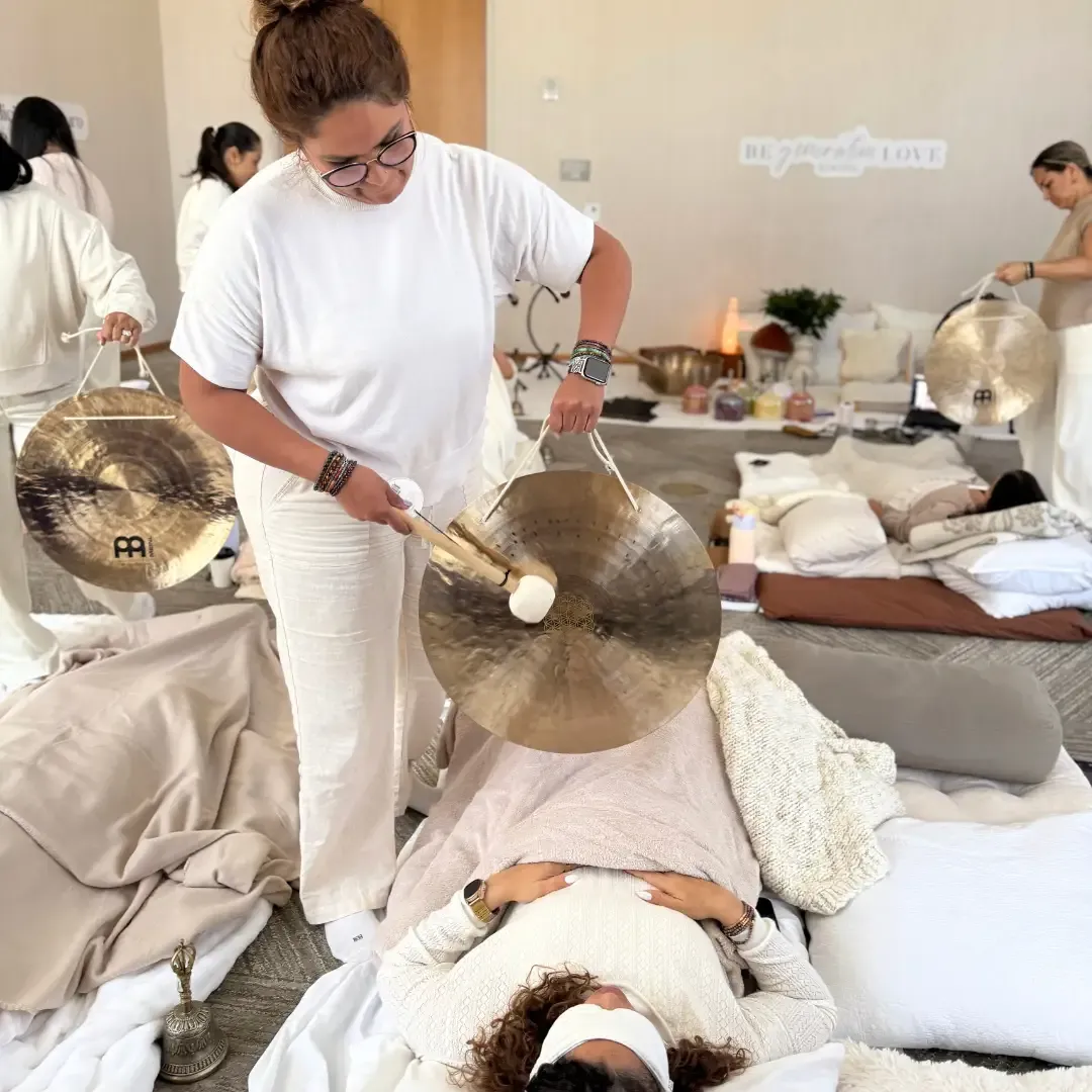 Fotografía de una mujer con las manos en el centro de su pecho mientras medita en la certificación de cuencos alquímicos cristal