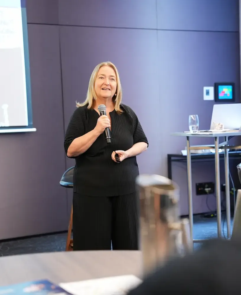 A woman business coach giving a presentation at an event
