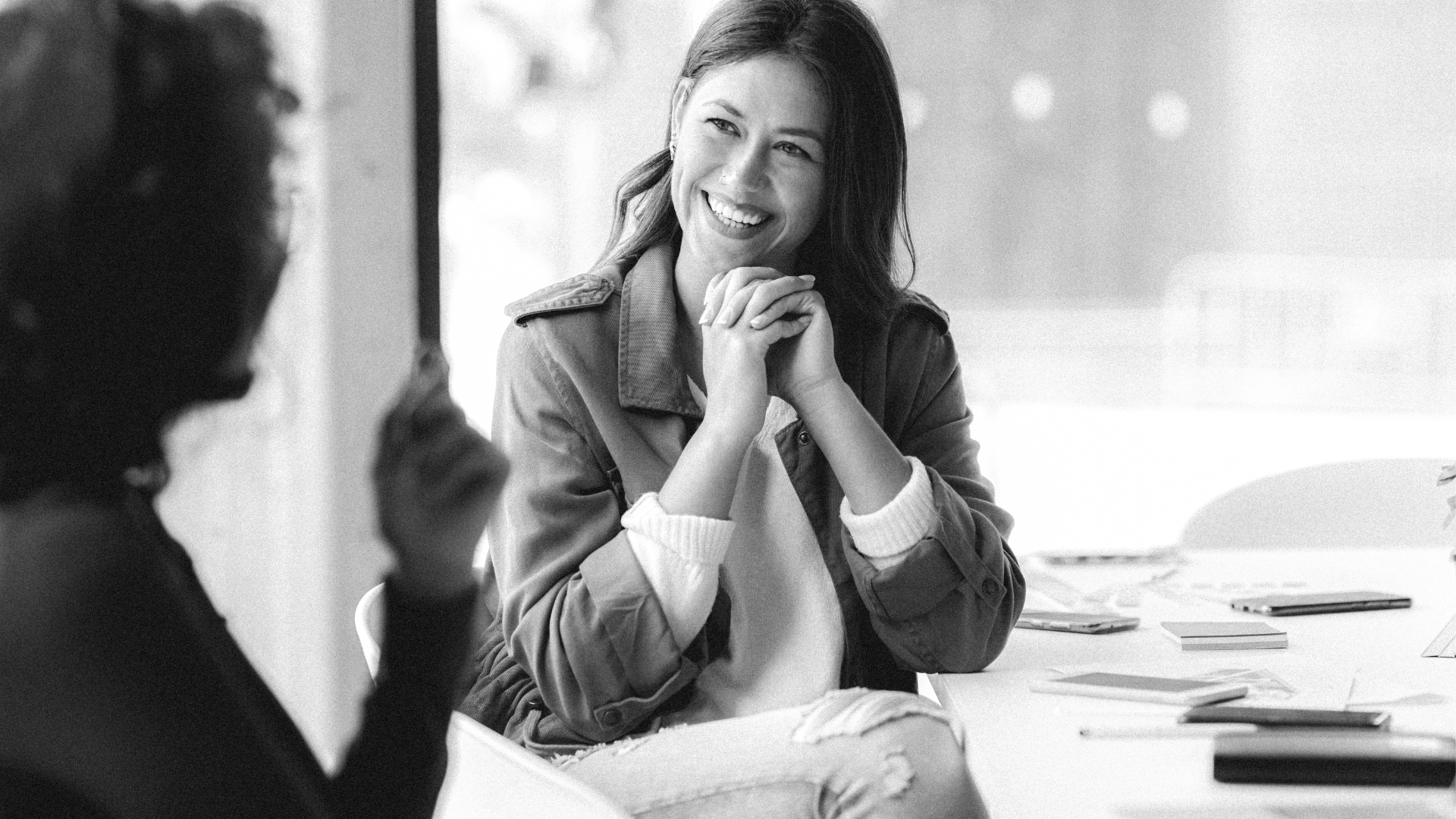 woman sat smiling chatting with her friend