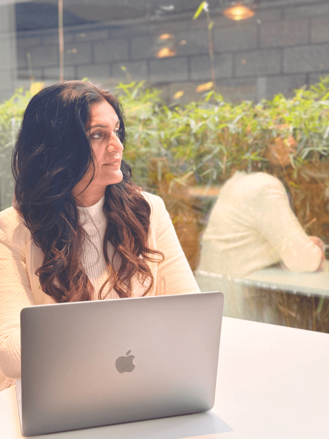 shaveta mehta with laptop looking outside