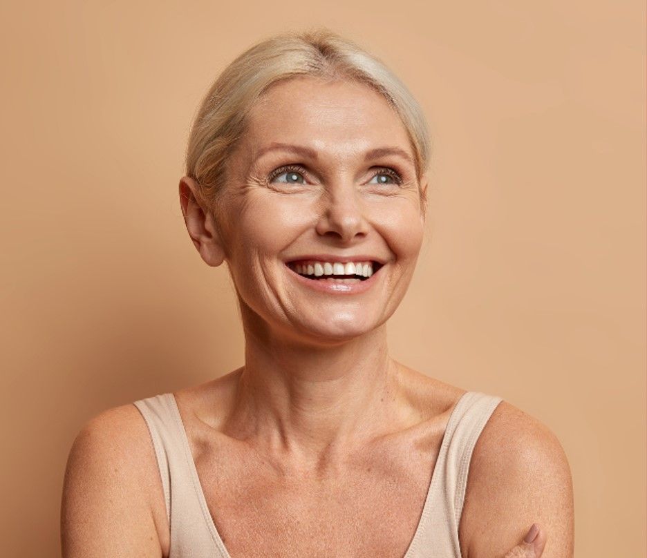 Eine gesunde Frau mittleren Alters sieht zuversichtlich und fröhlich in die Zukunft