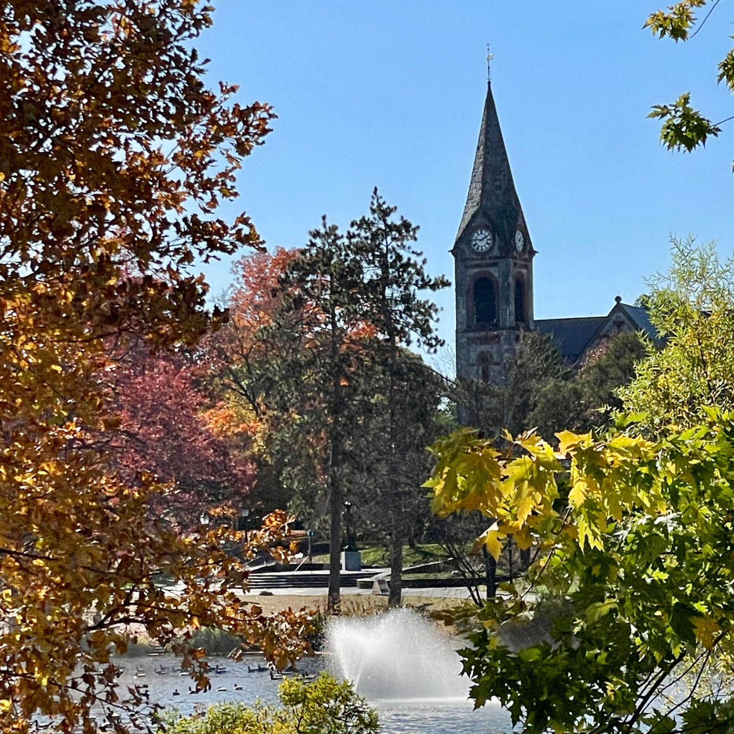 UMass Amherst chapel surrounded by trees and fountain