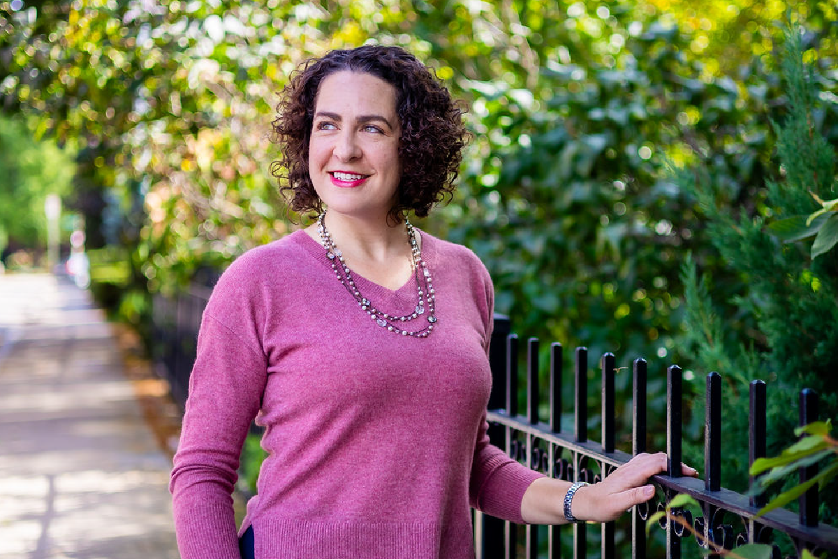 Erica Mattison stands outside, smiling