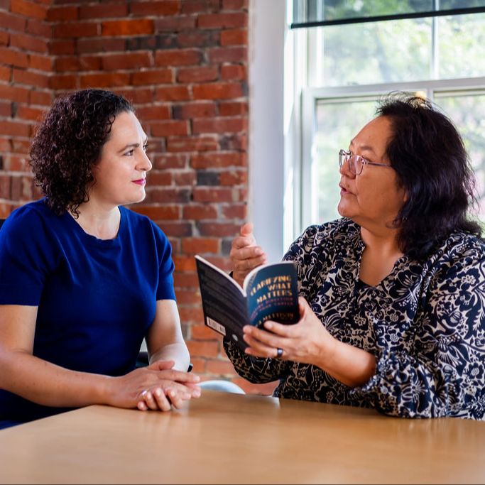 Erica Mattison and a client with Clarifying What Matters career book