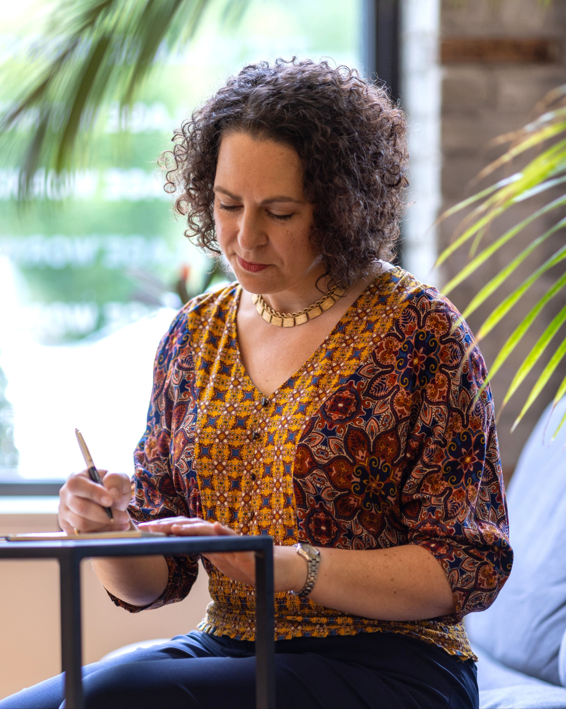 Erica Mattison writing in a reflective setting for a personal and professional development retreat