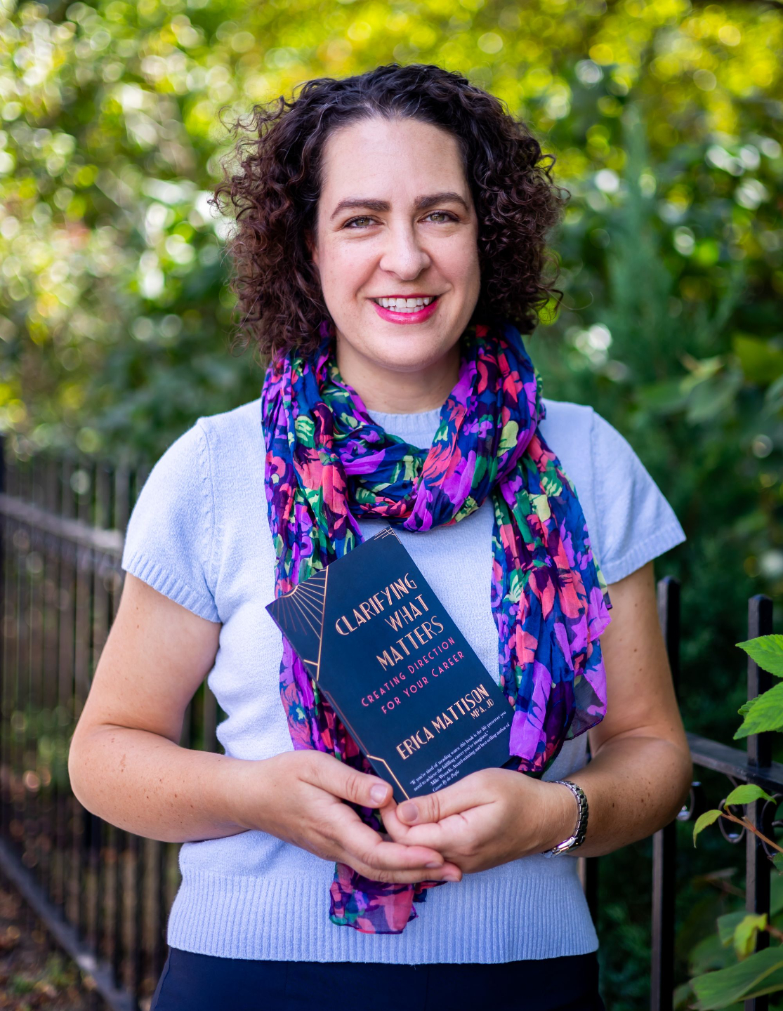 Erica Mattison holding her book Clarifying What Matters career clarity guide