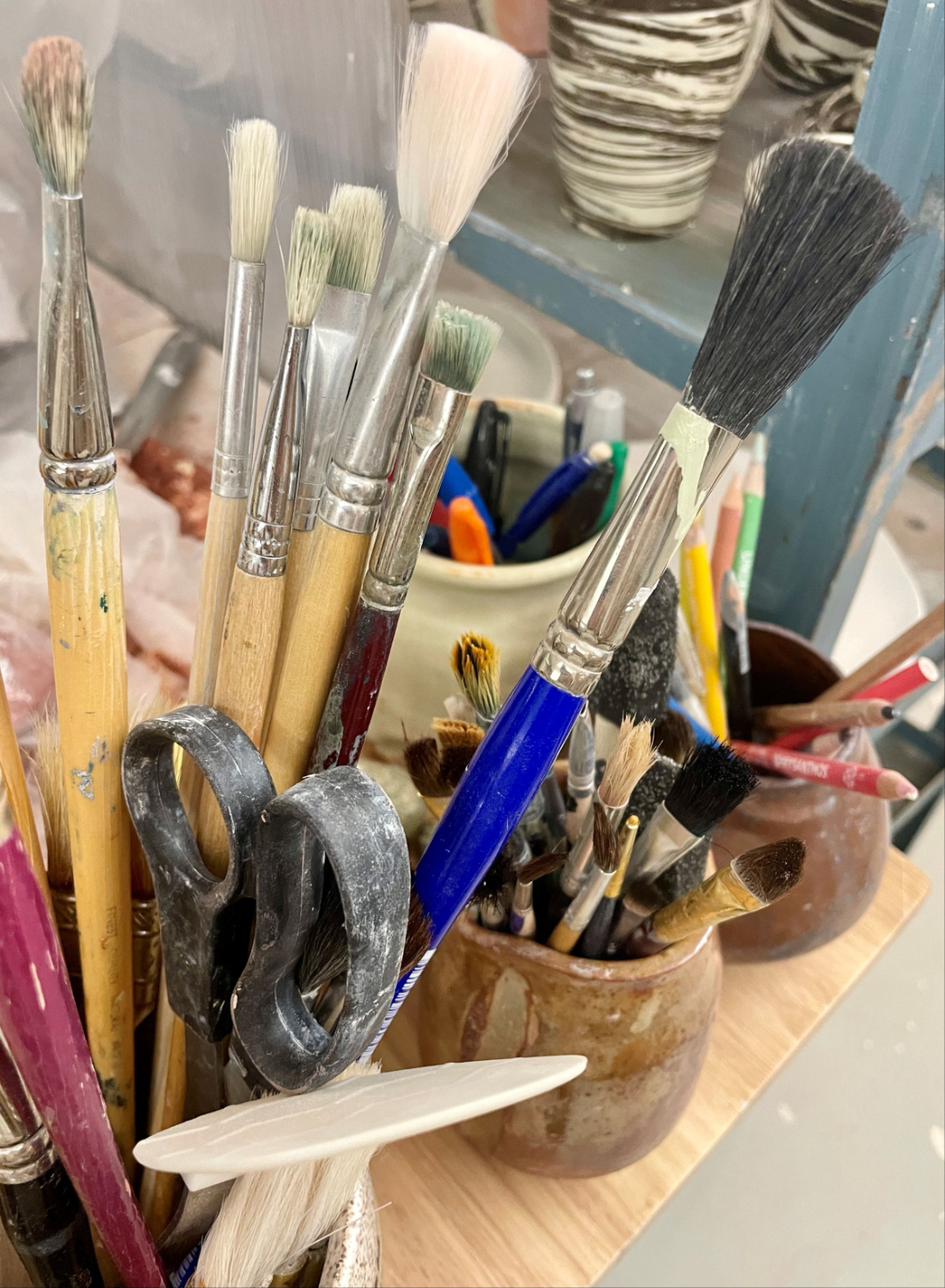 Paintbrushes in a jar, symbolizing creativity, reflection, and the process of clarifying what matters most at this stage of life.