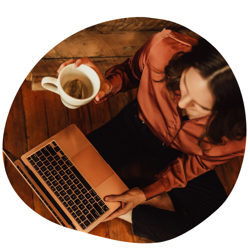 Woman working on a laptop with coffee, representing starting a health journey