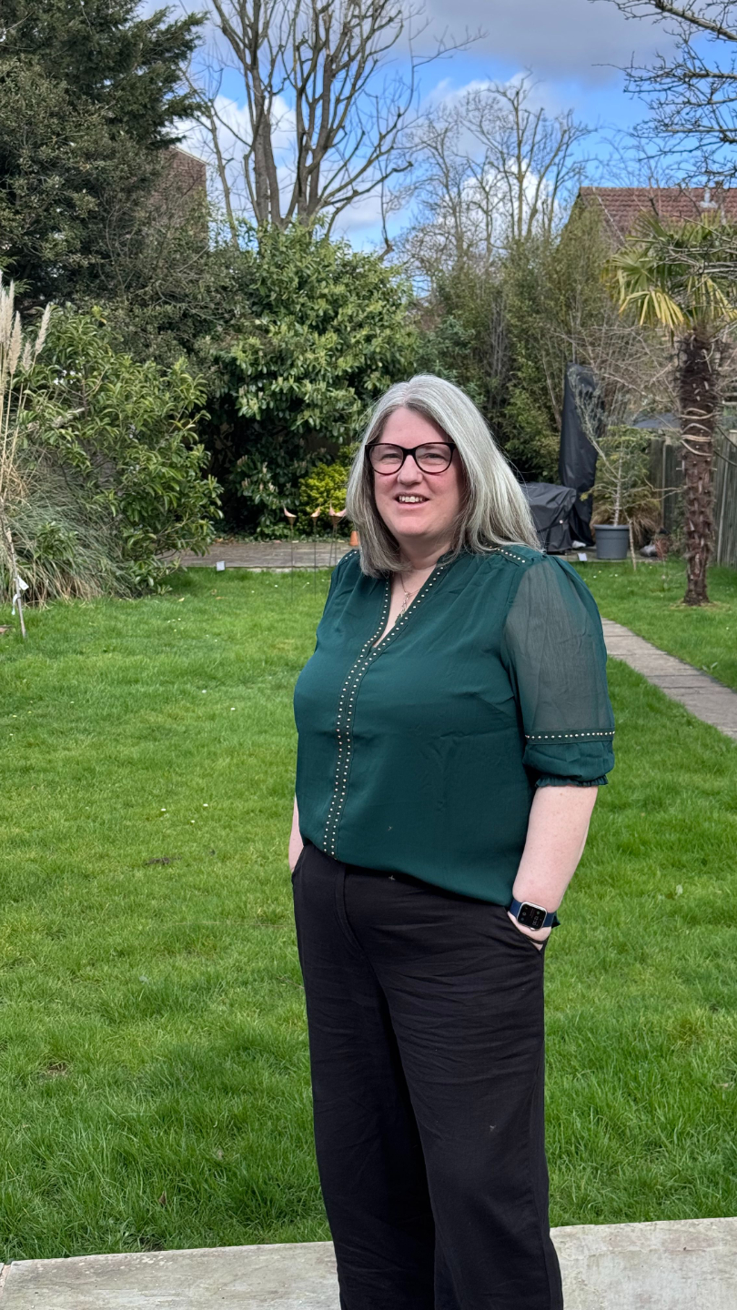 Lynsay McFarlane-Shaw OT supervisor, looking straight you, glasses on and green and white top