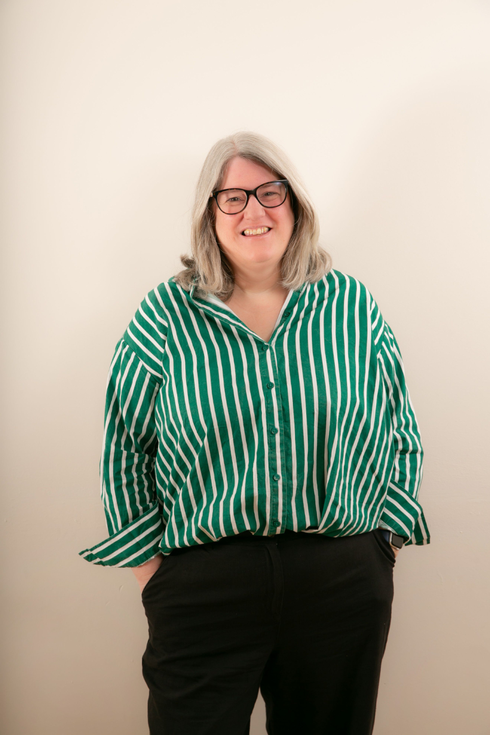 Lynsay McFarlane-Shaw OT supervisor, looking straight you, glasses on and green and white top