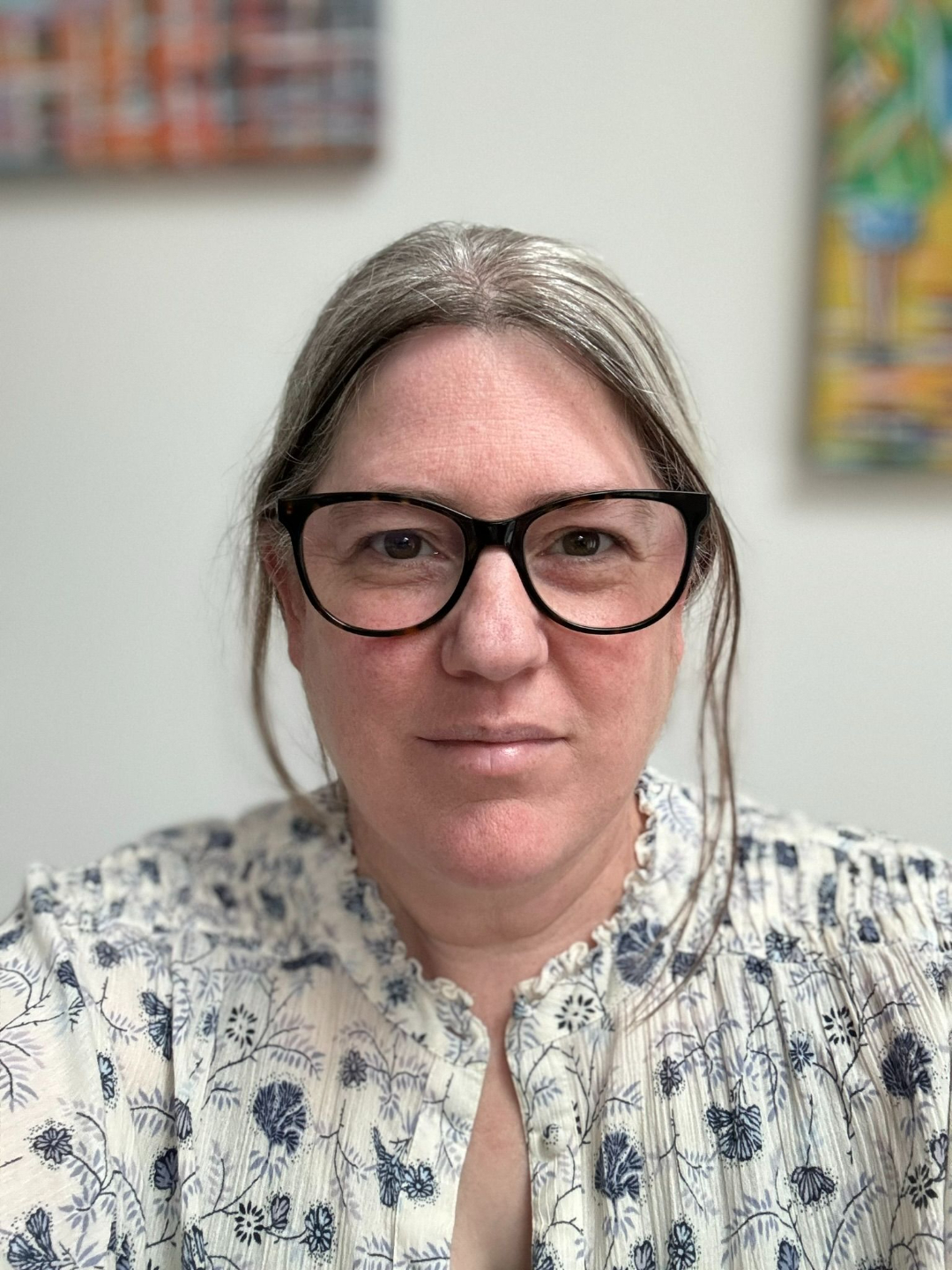 Lynsay OT supervisor, looking to the right of screen, white and blue top on