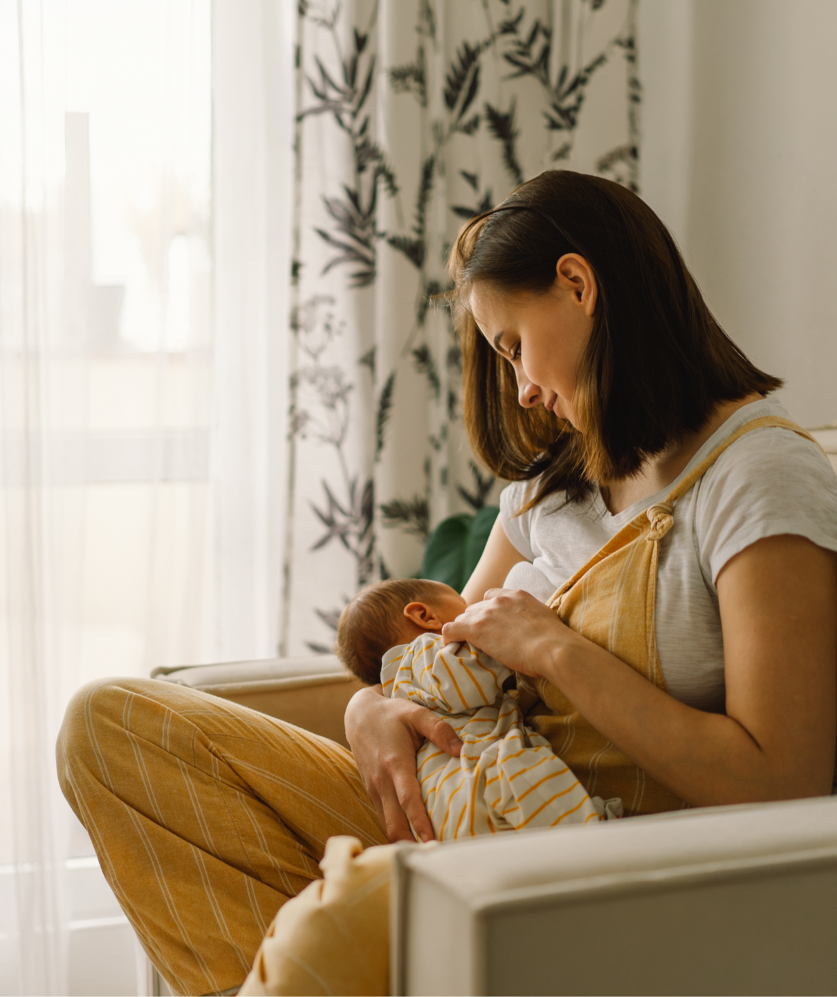 2 smiling women carrying a baby in a welcoming pose