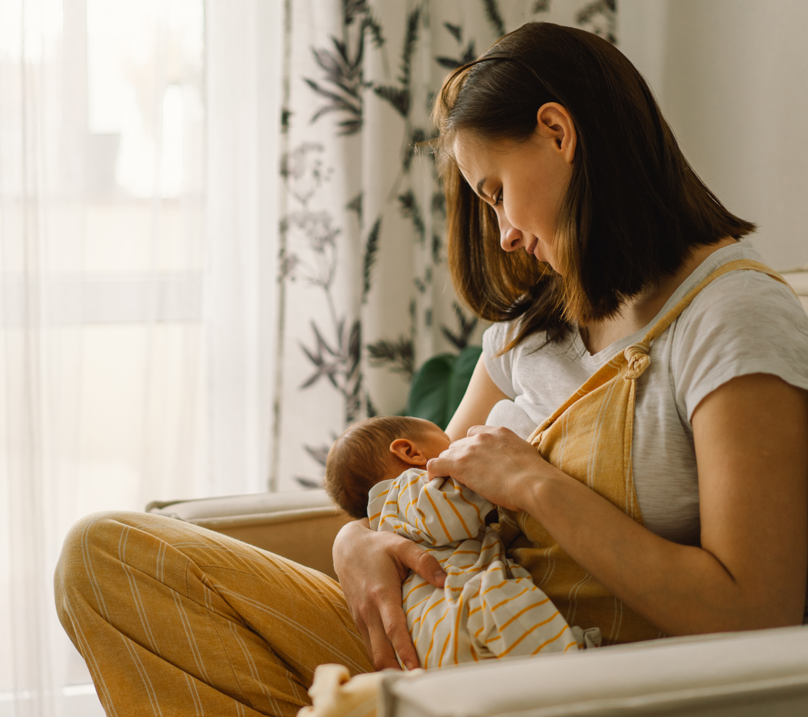 2 smiling women carrying a baby in a welcoming pose