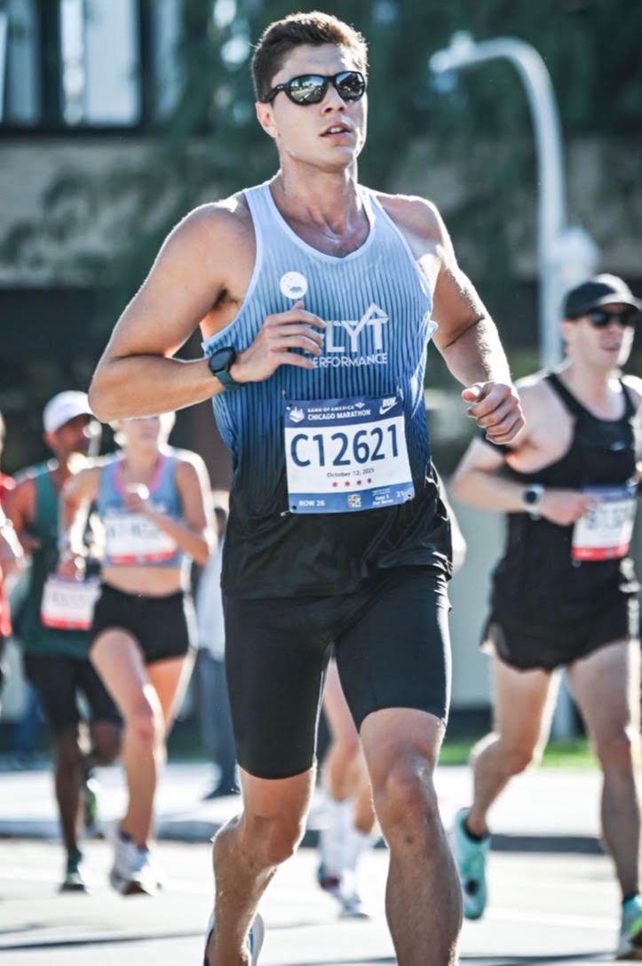 Person's head with swim cap and goggles surfacing pool water